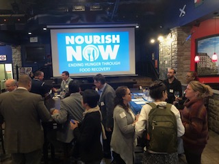 people near screen displaying nourish now